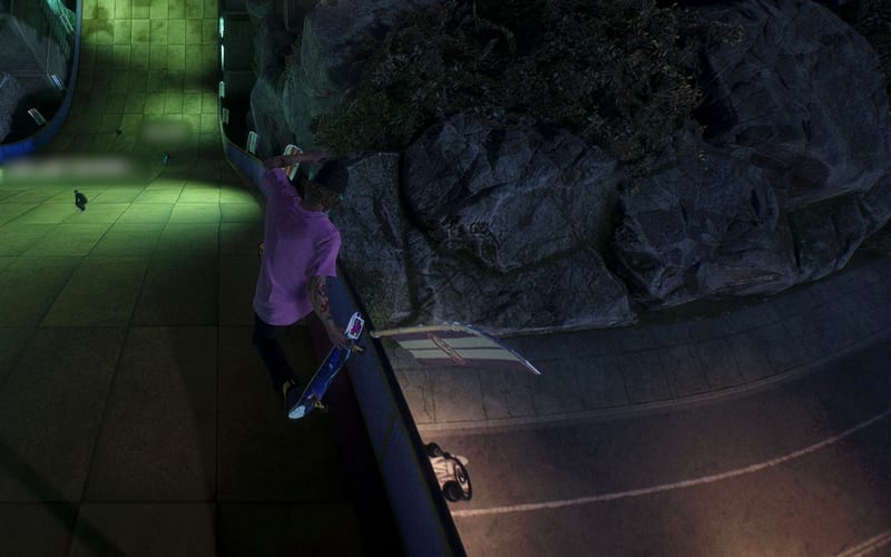 A skater in a pink tee grinds a curved ledge at night, with other skaters on the green-lit ramp behind.
