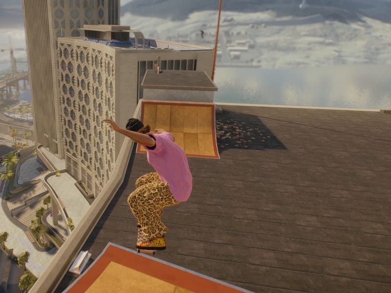 A skater rides up a rooftop ramp high above the city and the sea.