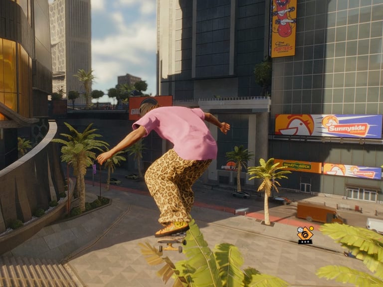 Gameplay from skate.: a skater in a pink tee ollies off a wooden ramp past palm trees in a sunny plaza.